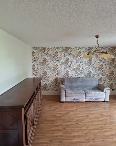 Séjour rénové à Eysines. Papier peint floral à raccord sur mur d'accent, peinture velours Unikalo, parquet
