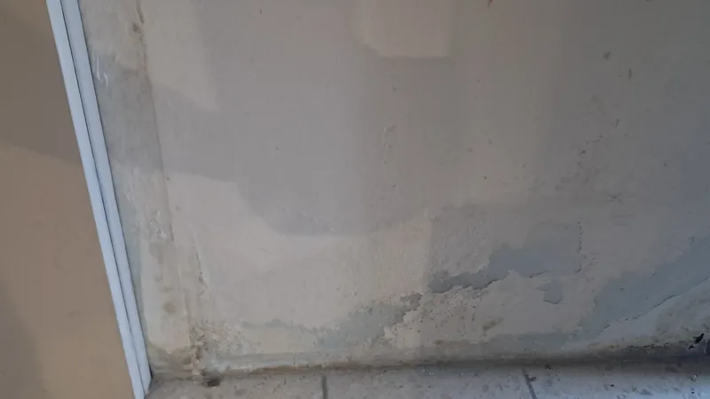 Mur endommagé par l'humidité avant traitement dans une salle de bain en Gironde